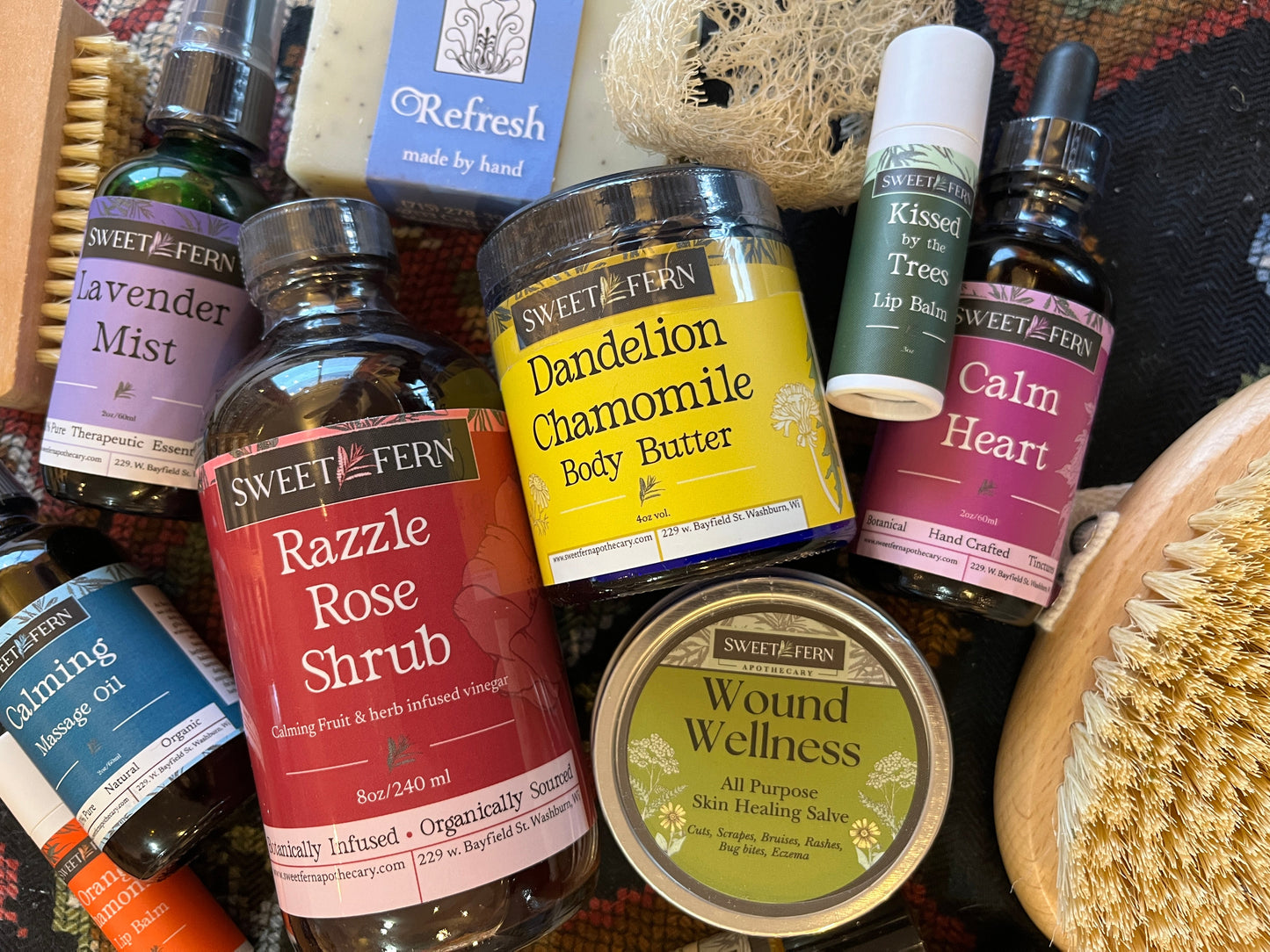 Collection of natural health and wellness products including bottles, jars, and a brush on a textured surface.