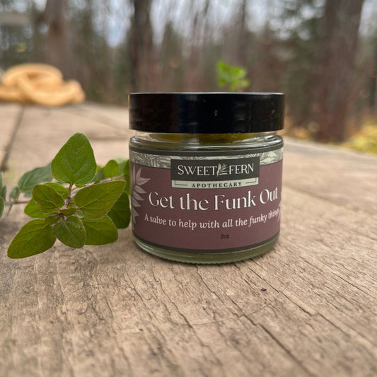 Jar of Get the Funk Out  fro Sweet Fern Apothecary, an herbal product on a wooden surface with blurred background