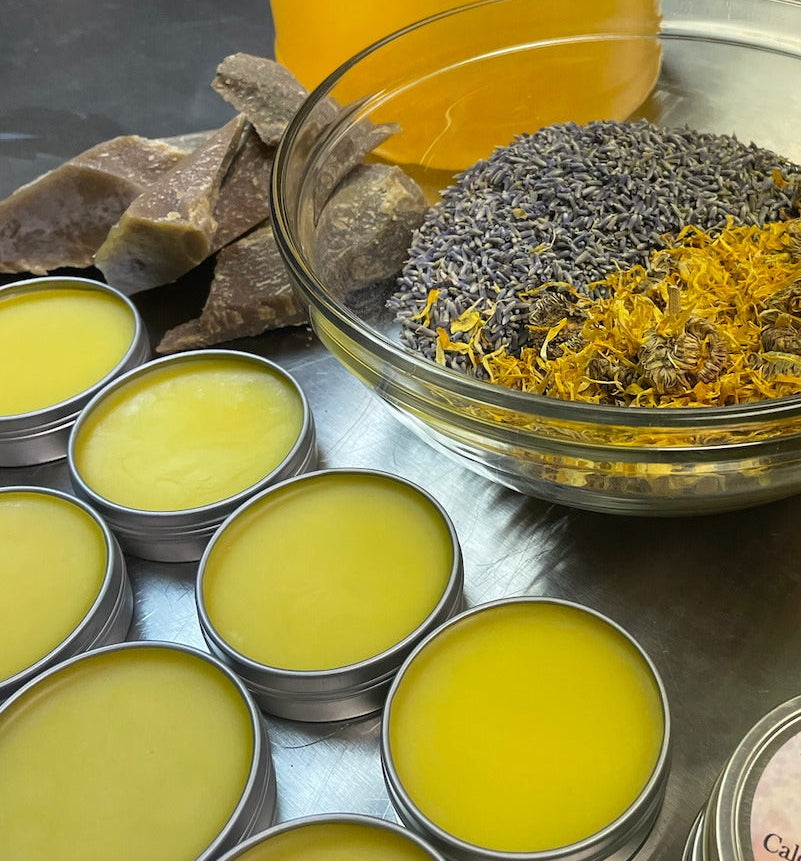 Ingredients for making Calendula Lavender salve with filled tins of Calendula Lavender Salve